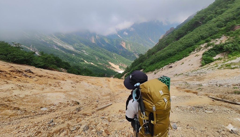 A female hiker walking step-by-step through a rugged mountain path, symbolizing the challenge of taking the first step on one's own uncharted route in life.